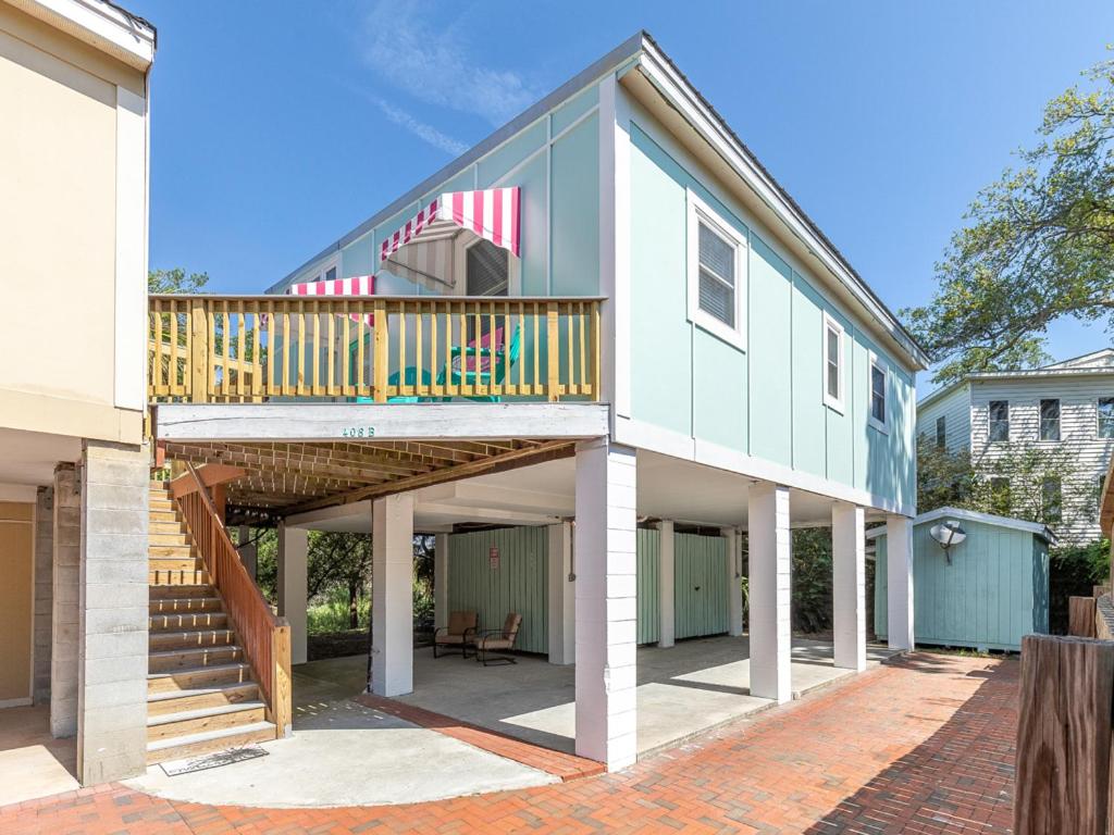 a large house with a deck and a patio at Treetop Cottage in Tybee Island