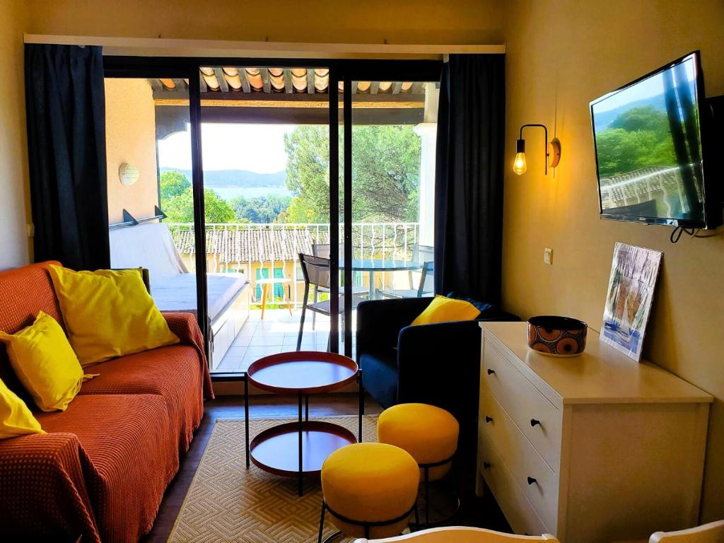 d'un salon avec un canapé et un balcon. dans l'établissement Résidence Les Parcs de Grimaud - maeva Home - Studio vue mer 4 personnes - Sélection MAE-3243, à Grimaud