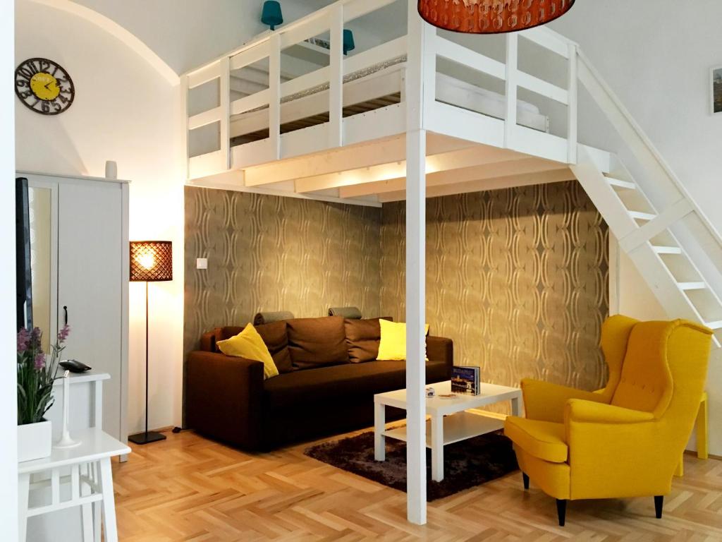 sala de estar con sofá y cama elevada en Lovag Apartman, en Budapest