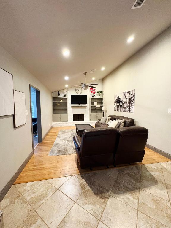 ラウンドロックにあるSpacious 4BR w Fenced Yardの黒いソファとキッチンのあるリビングルーム