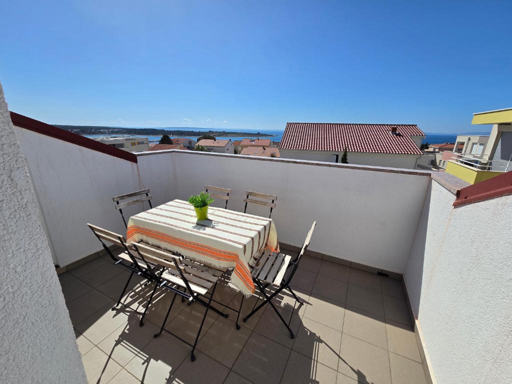 Un patio con una mesa y sillas en un balcón. en Villa Mandza, en Novalja