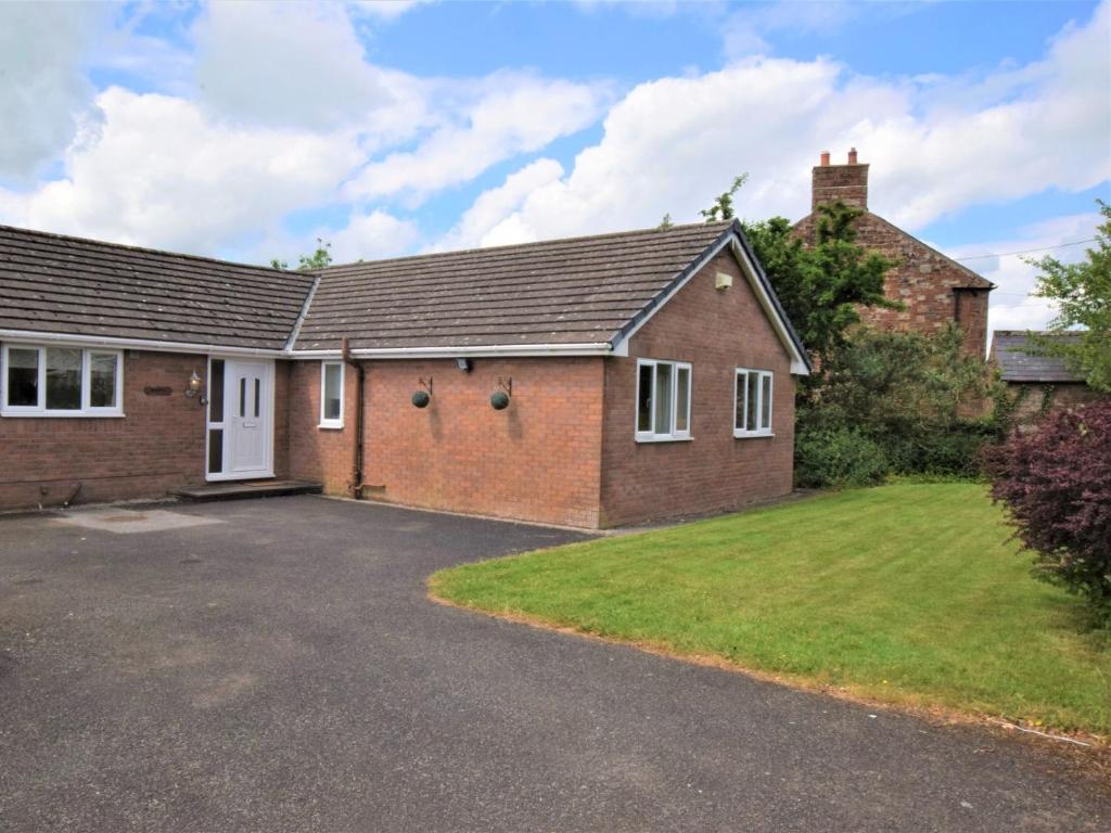 a brick house with a driveway in front of it at 4 bed in Ousby 80541 in Ousby