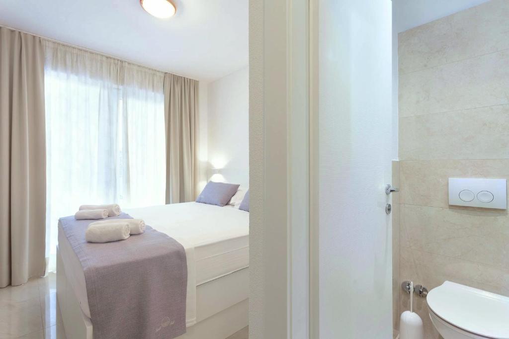 a small bedroom with a bed and a bathroom at Sunset Split Rooms in Podstrana