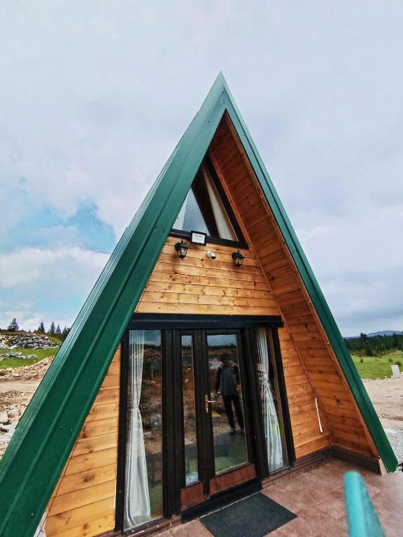 a small wooden house with a green roof at Squirrel's House in Žabljak