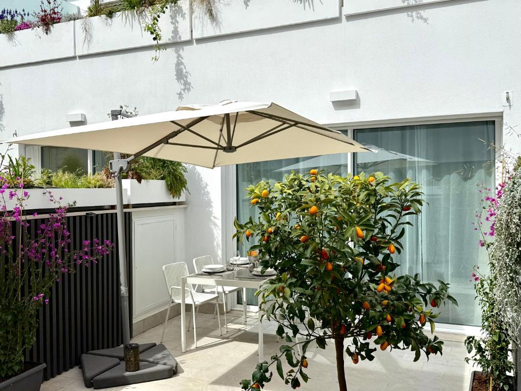 a patio with an umbrella and a table with an orange tree at Suite with Private Courtyard - Colosseum & Forum in Rome