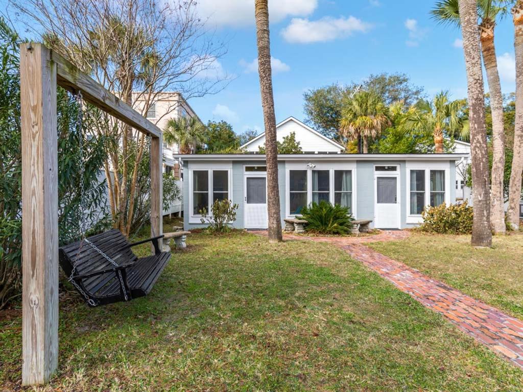 una casa con palmeras y un columpio en Captains Quarters B, en Tybee Island