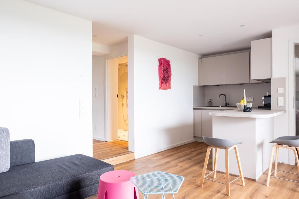 Una sala de estar con un sofá y una cocina. en NH22 Apartments, en Ravensburg