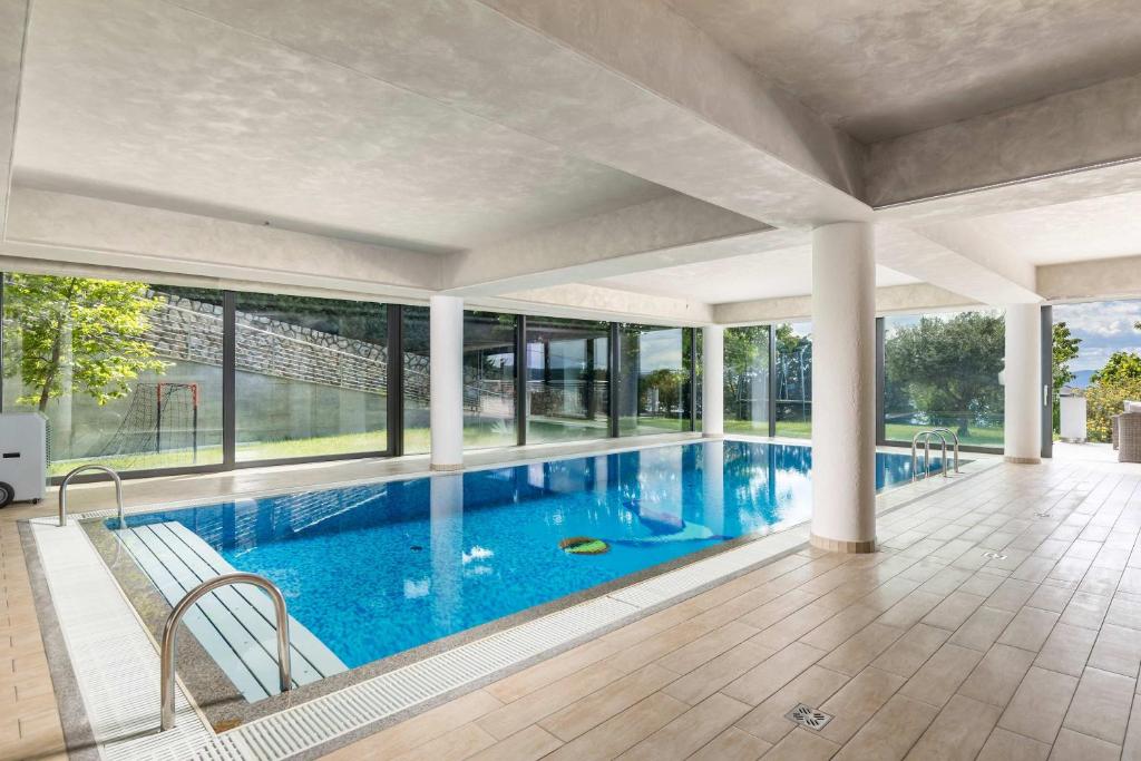 a large swimming pool with glass windows in a house at Wellness Villa Biocrystal in Bakarac