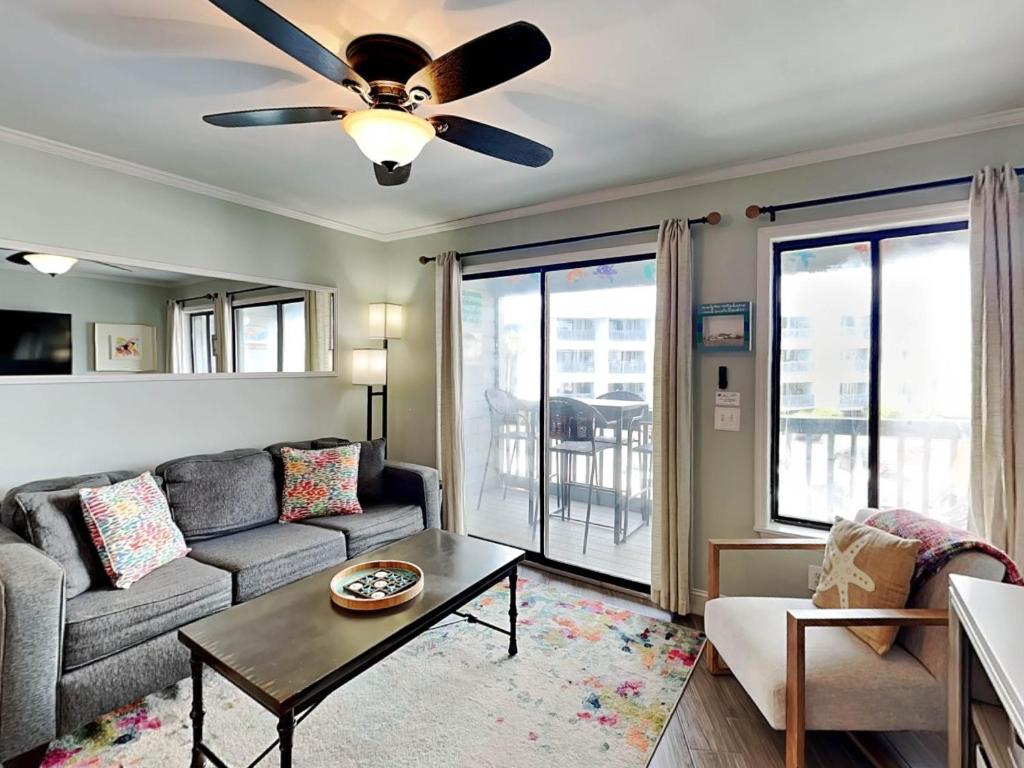 un salon avec un canapé et un ventilateur de plafond dans l'établissement Beach Racquet A209, à Tybee Island