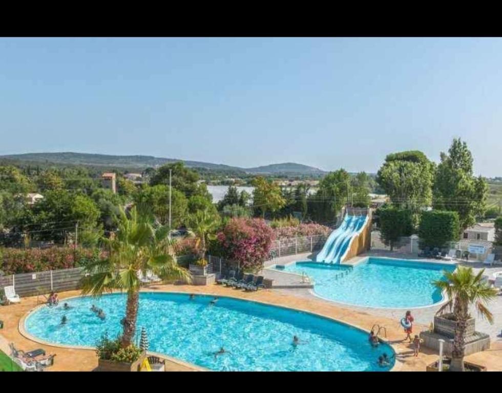 une grande piscine avec un toboggan aquatique dans l'établissement Mobile home, à Vic-la-Gardiole