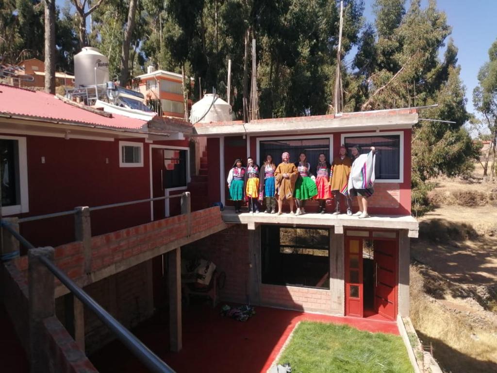 Un gruppo di persone che si trovano sopra una casa di Illariywasi Homestay Comunidad Pueblo Isla Amantani a Ocosuyo