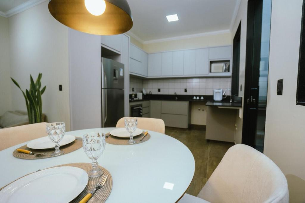 a kitchen with a white table and chairs and a table and chairsktop at Residência TCA in Brasilia