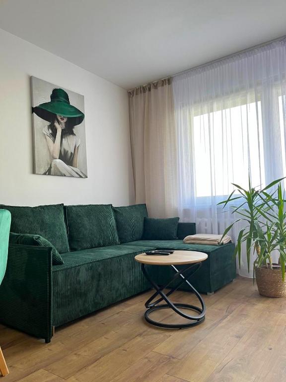 a living room with a green couch and a table at Apartament 49 in Toruń