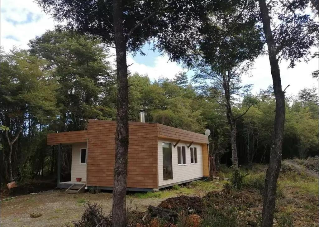 a small cabin in the woods with trees at Cabaña aeropuerto Puerto Montt in El Tepual