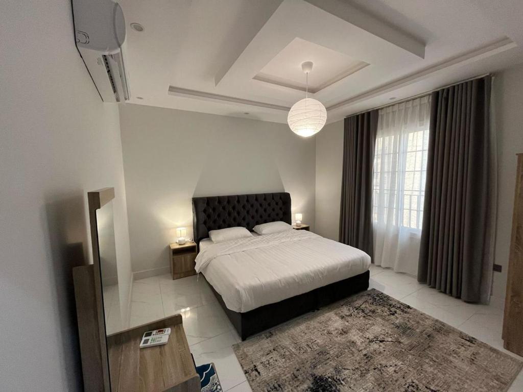 a bedroom with a bed and a large window at Aldiyafah Apt Jeddah in Jeddah