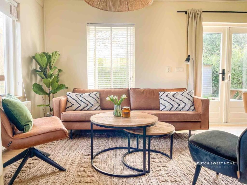 a living room with a couch and a table at The Soultree - Stylish nature cottage near Schoorl dunes & Bergen beach in Warmenhuizen
