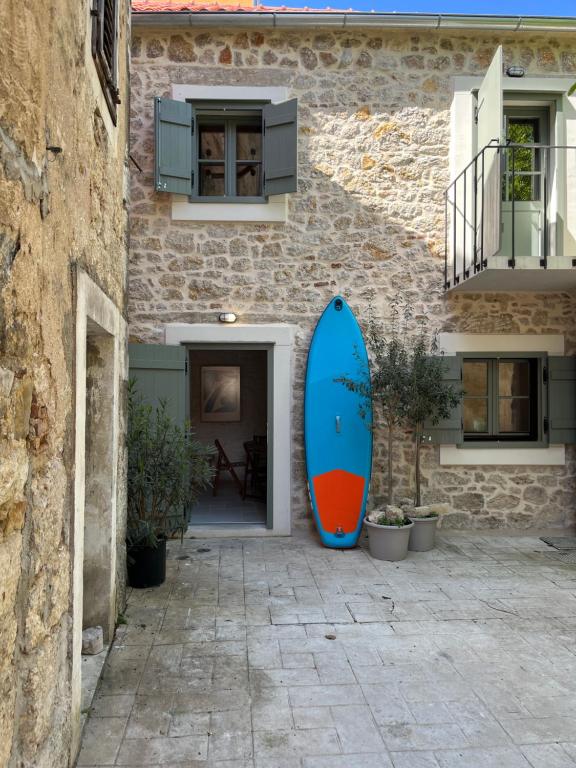 a blue surfboard leaned up against a building at Stonehouse Zrmanja in Obrovac