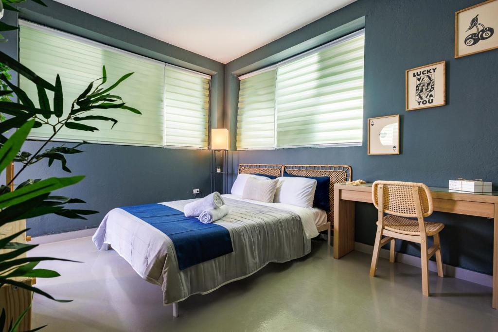 a bedroom with a bed and a desk and window at Spanish Lagoon San Juan with Private Patio by PH in San Juan