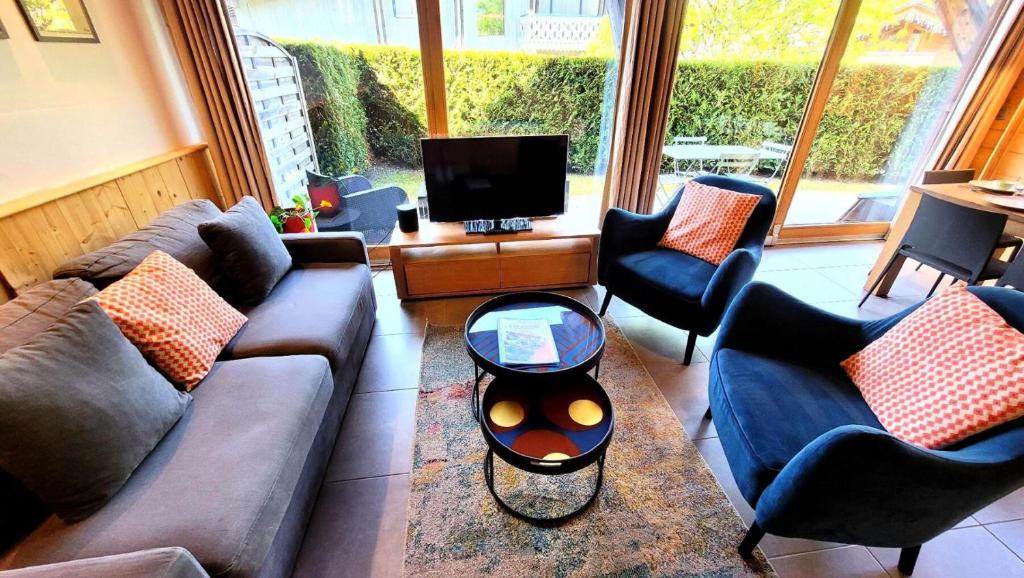 un salon avec un canapé, des chaises et une télévision dans l'établissement Résidence Hermitage Ii - Appartement proche centre et pistes MAE-2381, aux Gets