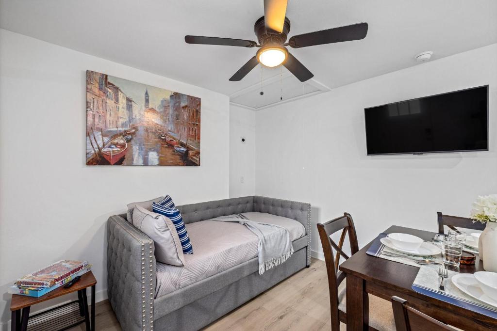 een woonkamer met een bank en een plafondventilator bij Downtown Heights Flat Games TVs WiFi Pets in Houston