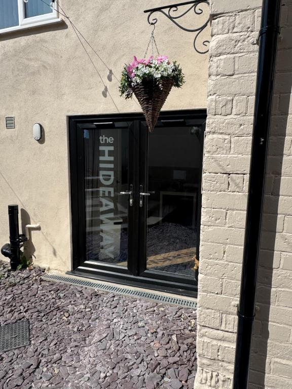a door to a store with a basket of flowers at Valletta House Holiday Apartments in Skegness