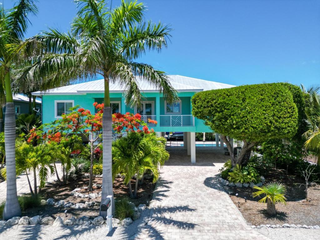 a house on the beach with palm trees and flowers at Villa Lucie in Summerland Key