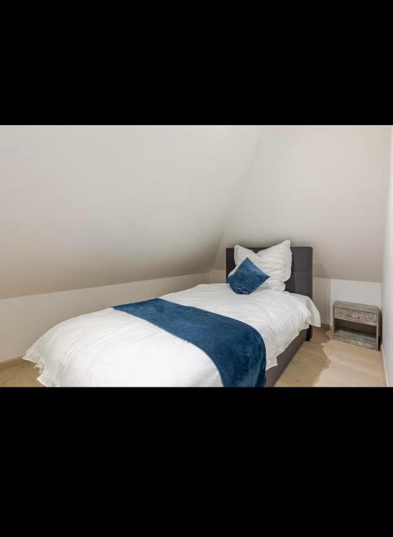 - une chambre avec un lit blanc et une couverture bleue dans l'établissement Apparemment neuf entrée indépendante, à Hœrdt