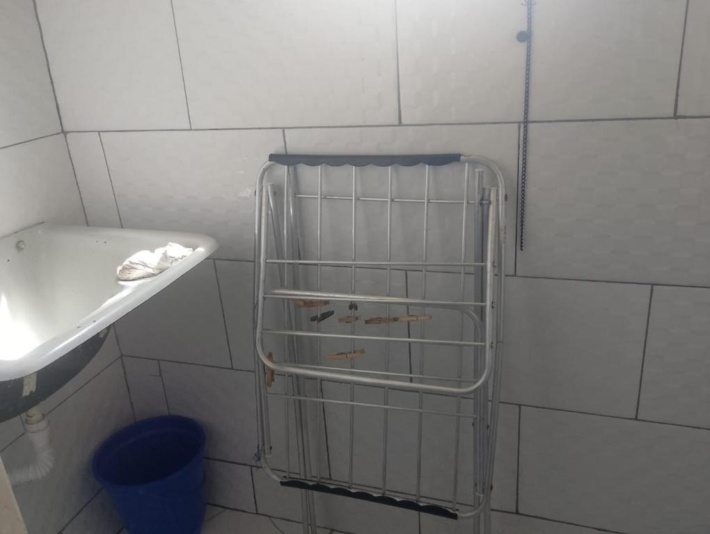 a bathroom with a sink and a metal rack at Kitnet PRAIA GRANDE in Arraial do Cabo