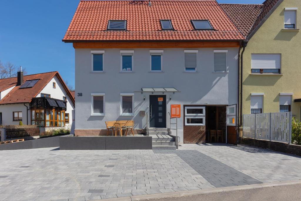 ein großes weißes Haus mit rotem Dach in der Unterkunft Lewe`s Ferienwohnungen in Dettingen an der Erms