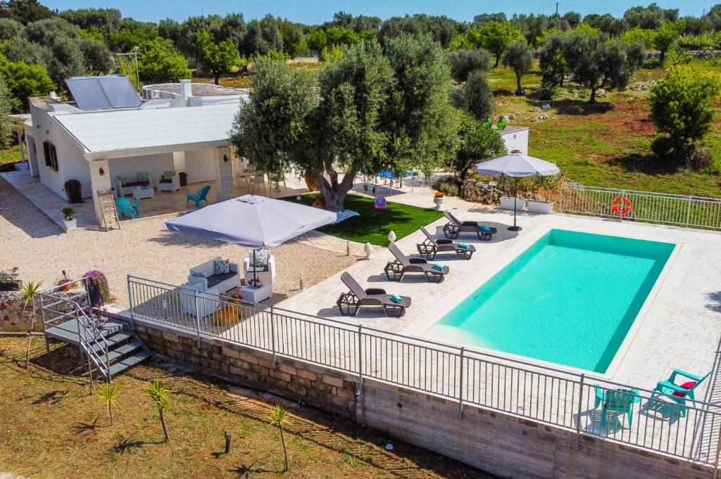an overhead view of a swimming pool with chairs and umbrellas at Villa Tiffany by Villa Plus in Carovigno