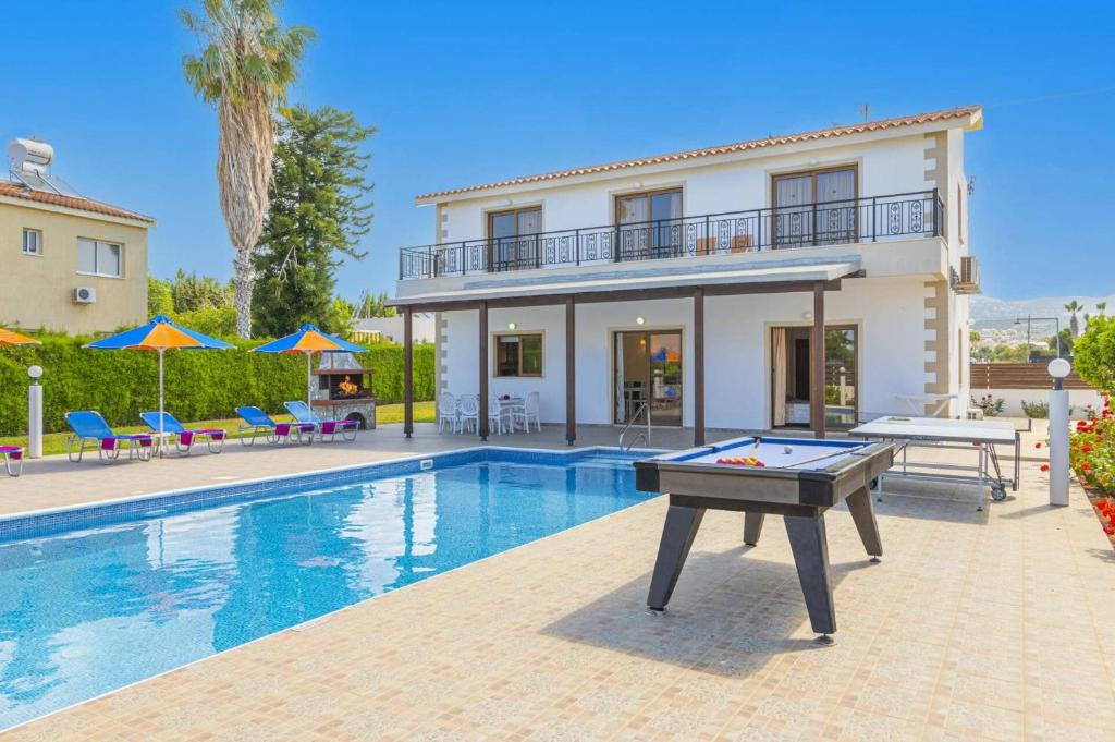 a villa with a pool and a pool table at Villa Heracles by Villa Plus in Peyia