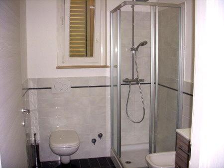 ein Bad mit einer Dusche, einem WC und einem Waschbecken in der Unterkunft Appartamenti Romita in Cupra Marittima