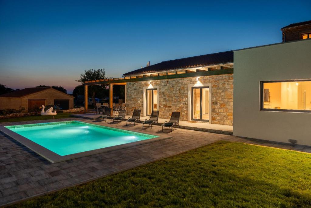 a swimming pool in the backyard of a house at Villa Veduta in Bale