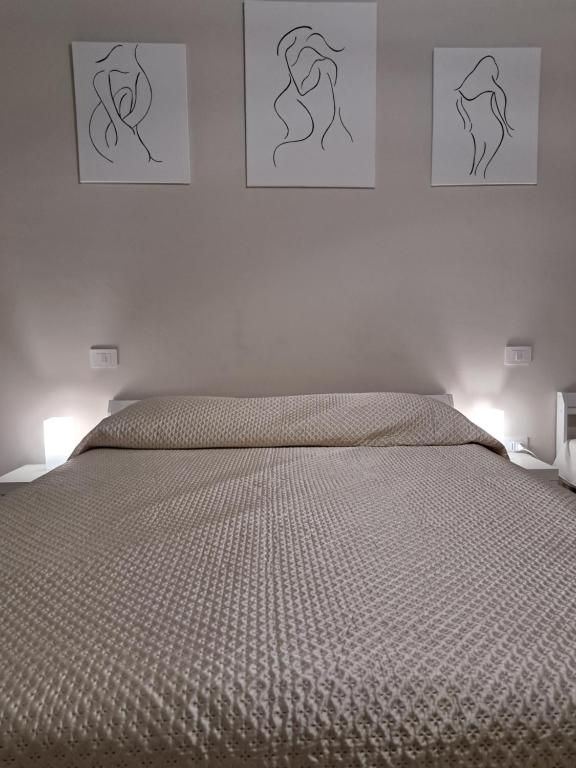 une chambre avec un lit avec trois tableaux au mur dans l'établissement La casa di Titty, à Reggio de Calabre