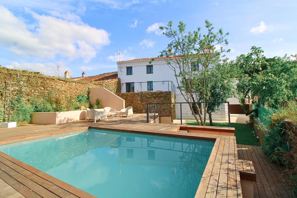una piscina con terraza de madera y una casa en Casa del Angel by SIERRA VIVA, en Los Marines