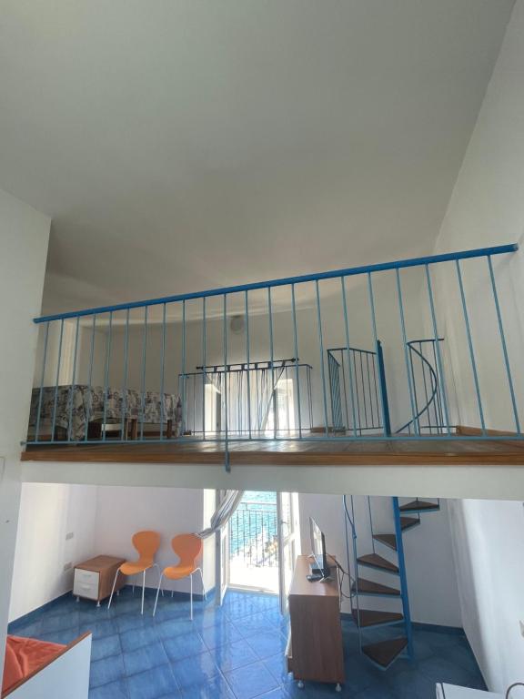 a staircase in a house with orange chairs at Agenzia Isotur LOCANDA NONNA GIULIA 33 VISTA MARE- SOPPALCATA in Ponza