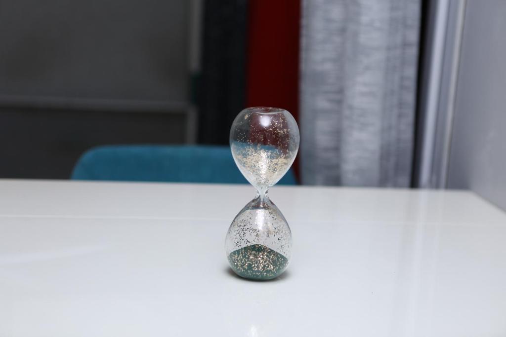un sablier posé sur une table blanche dans l'établissement Appartement T2 Confortable à Lyon, à Lyon