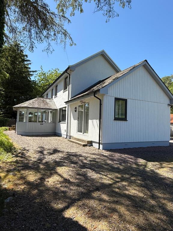 a large white house with a large driveway at Highland Hideaway in Fort William