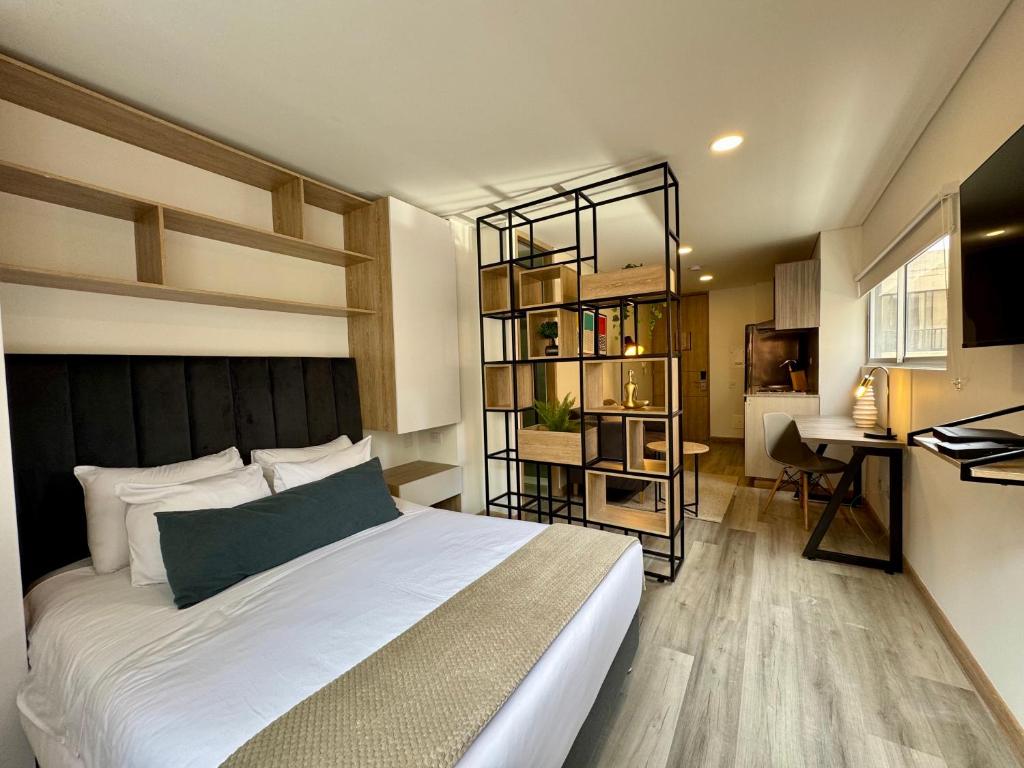 a bedroom with a bed and a desk in it at Cozy Loft in 93 park in Bogotá
