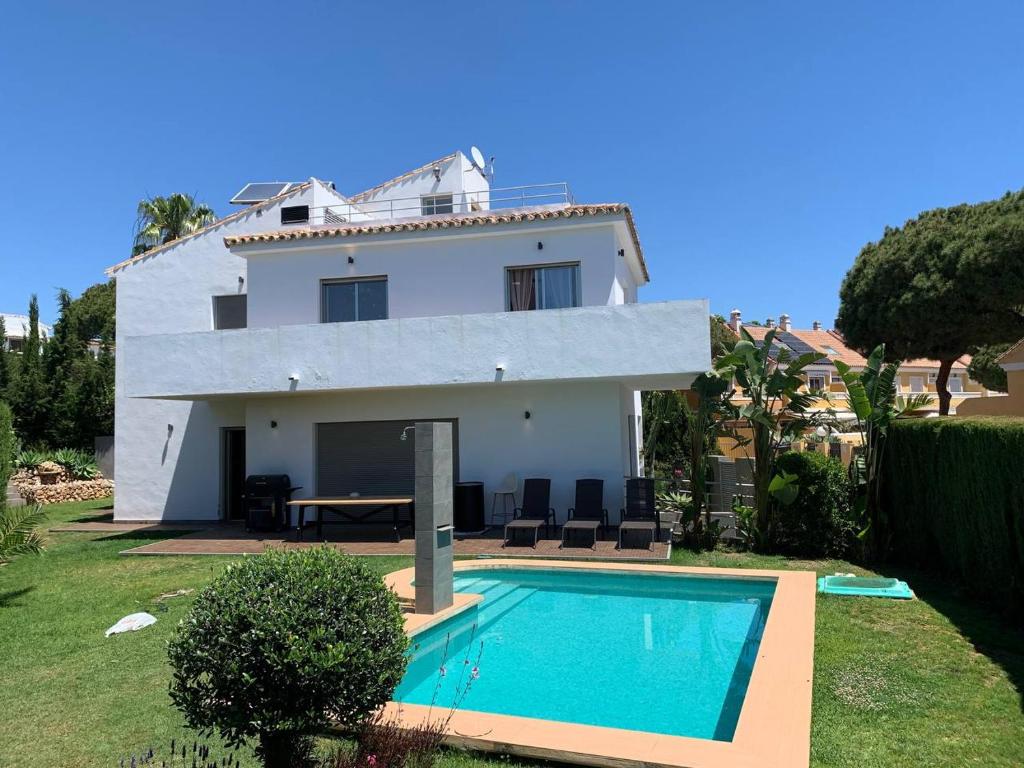 a house with a swimming pool in front of it at Villa Serena near the beach in Mijas Costa