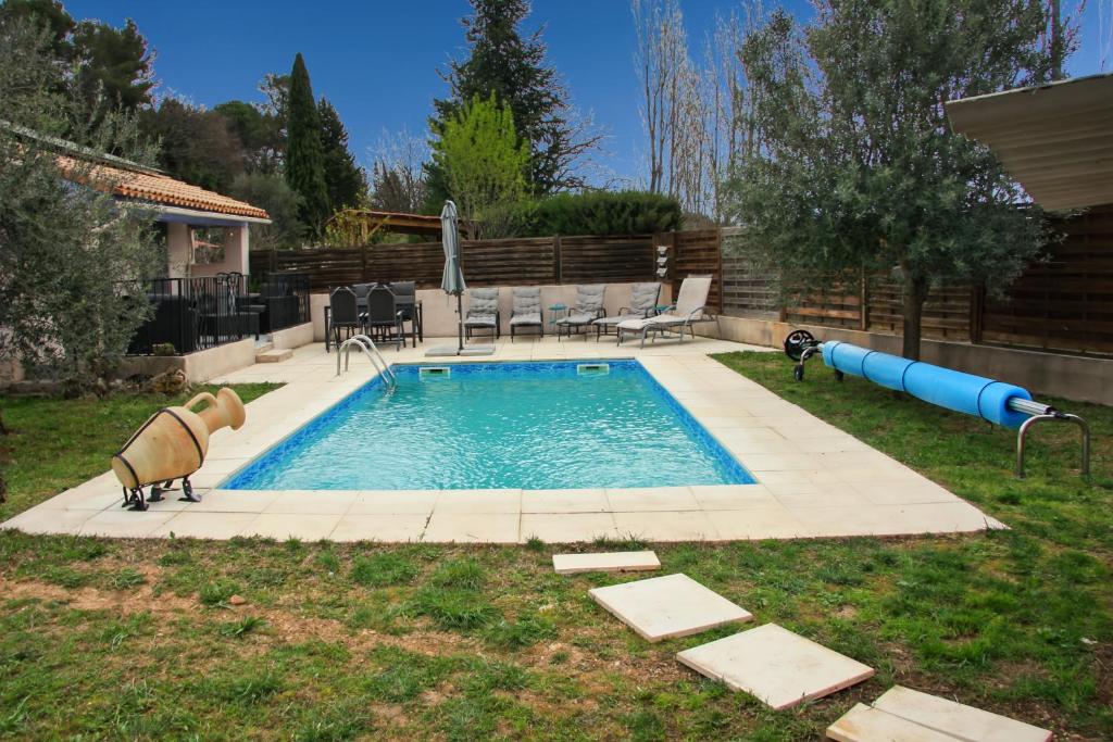une piscine dans une cour avec deux animaux debout à côté dans l'établissement Maison avec piscine au calme, à La Roquebrussanne