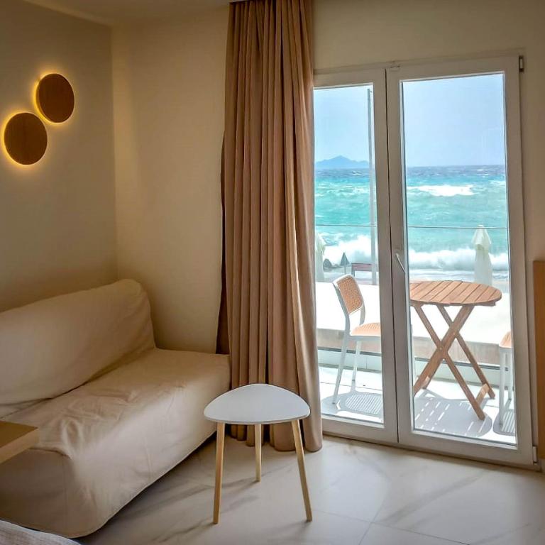 a living room with a couch and a view of the ocean at Royal King David in Kardamaina