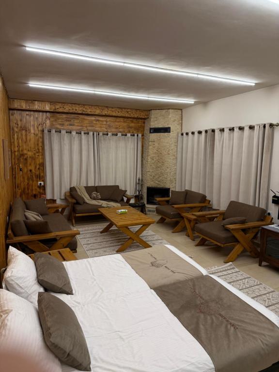 a bedroom with a large bed and chairs and a couch at Oak Farm مزرعة البلوط in Ajloun