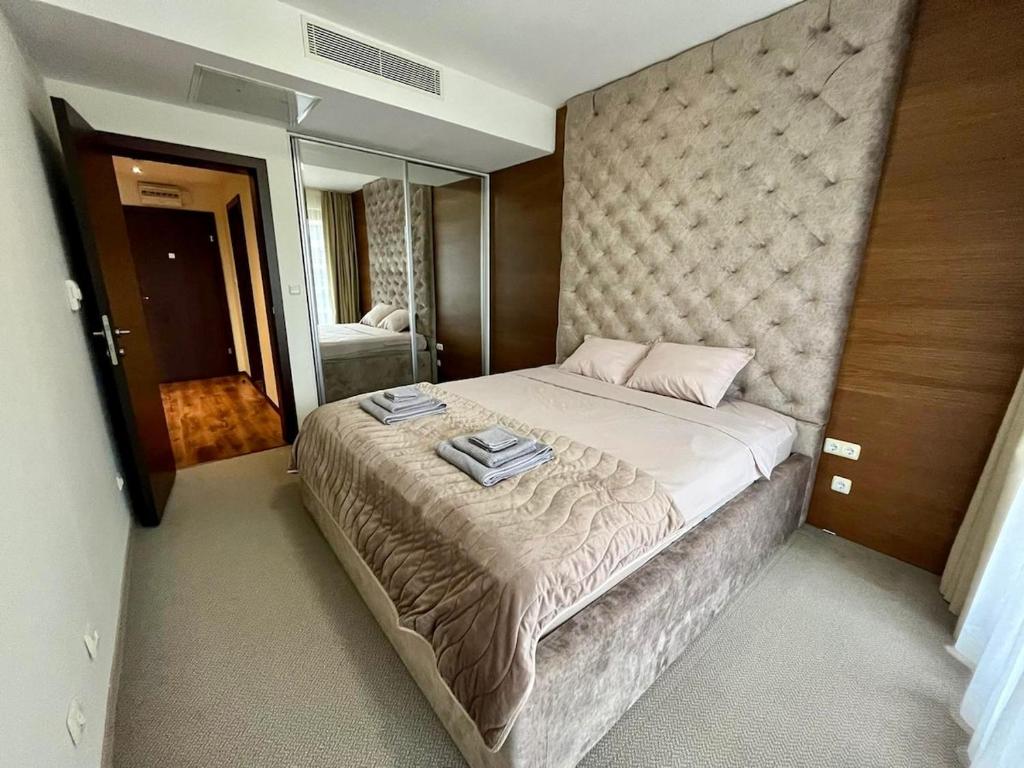 Un dormitorio con una cama grande con dos toallas encima. en Platinum apartment, en Bŭnzareto