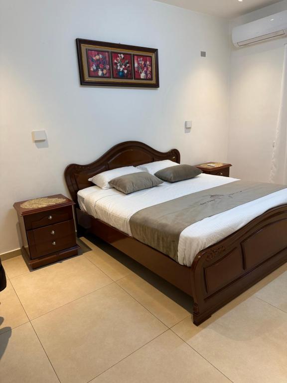 a bedroom with a large bed and a night stand at Oak Farm مزرعة البلوط in Ajloun