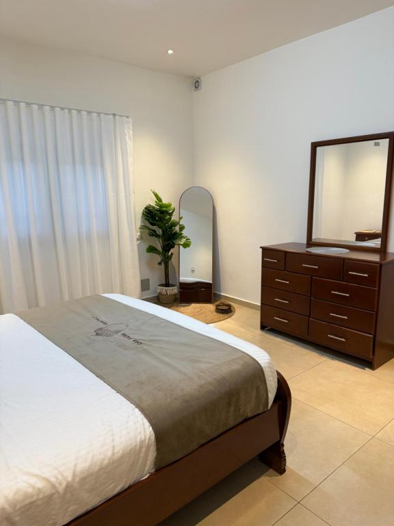 a bedroom with a bed and a dresser and a mirror at Oak Farm مزرعة البلوط in Ajloun
