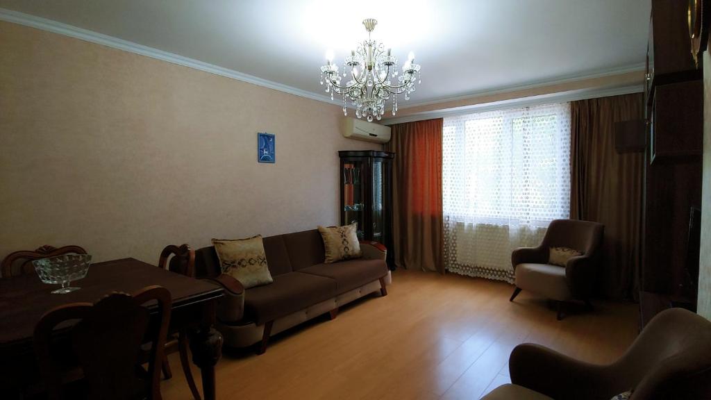 sala de estar con sofá, mesa y lámpara de araña en App, en Itʼkhvisi