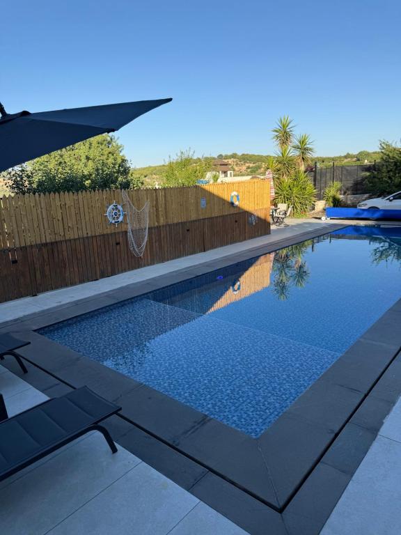 a swimming pool in a backyard with a wooden fence at Oak Farm مزرعة البلوط in Ajloun