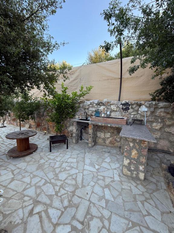 a stone patio with a table and a stone wall at Oak Farm مزرعة البلوط in Ajloun