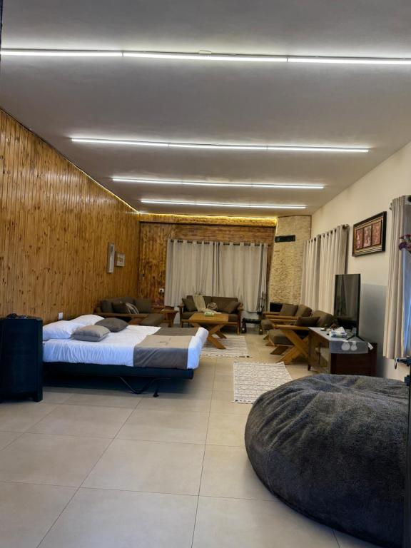 a bedroom with two beds and a living room with a couch at Oak Farm مزرعة البلوط in Ajloun